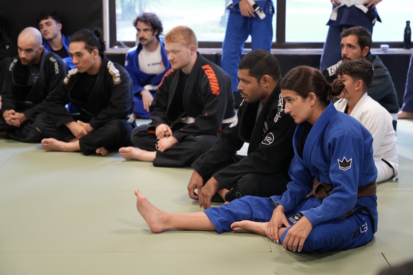 Alumnos sentados escuchando la clase de Jiu-Jitsu en NEKO