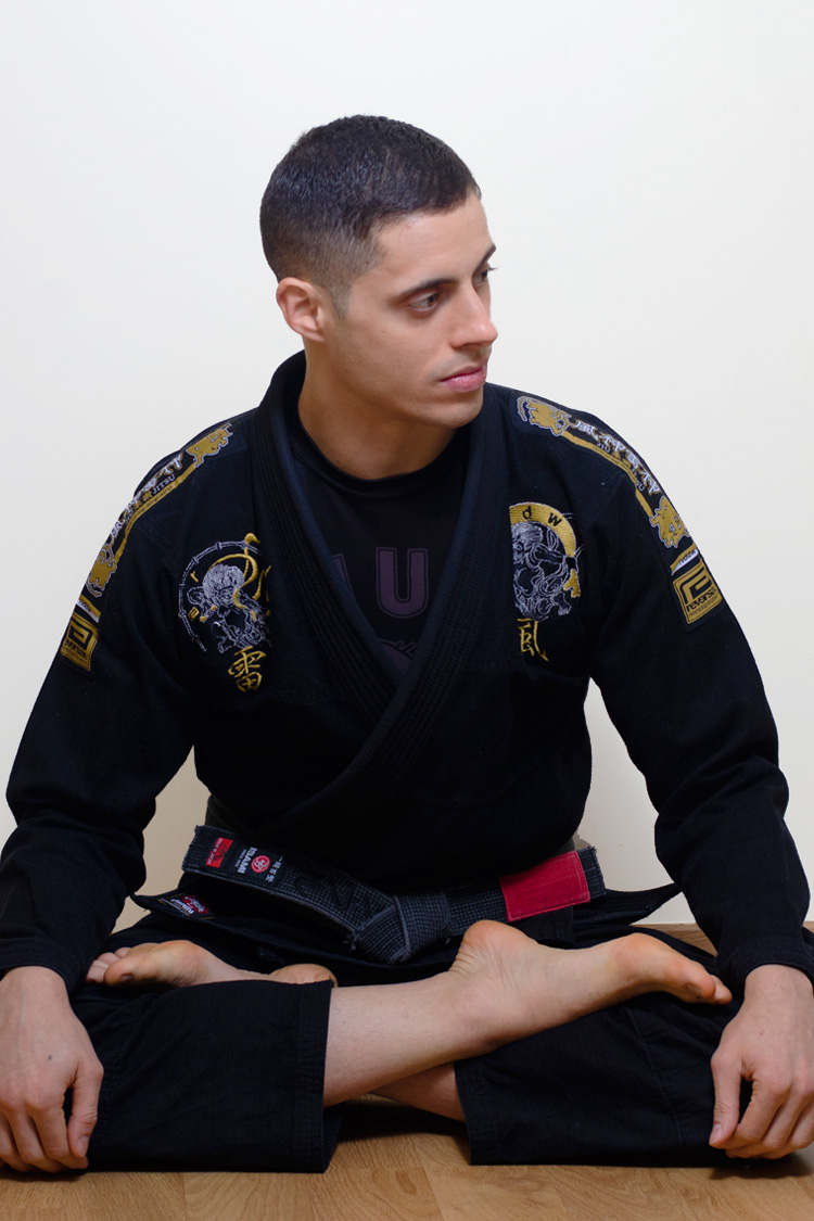 Raúl Cantero, fundador e instructor de NEKO Jiu-Jitsu en Madrid, con kimono negro sentado en el tatami